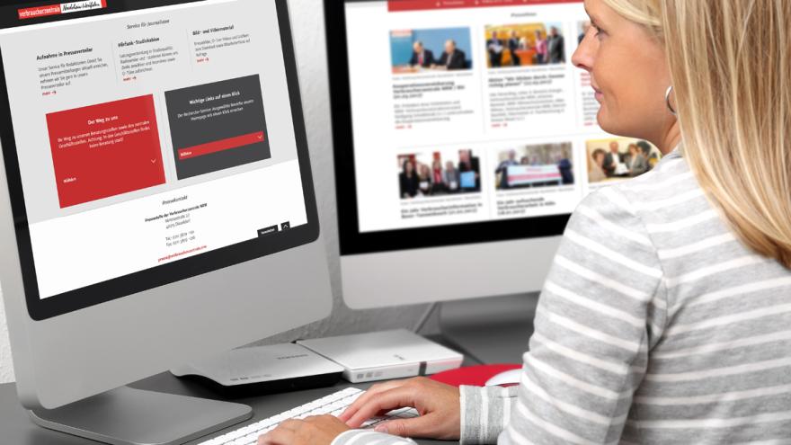 Eine Frau sitzt vor zwei PC-Bildschirmen