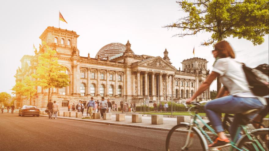 Eine Fahrradfahrerin vor dem Reichstag.