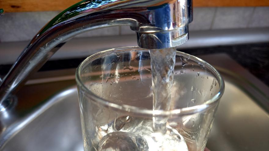 Fließendes Wasser aus dem Wasserhahn in ein Glas