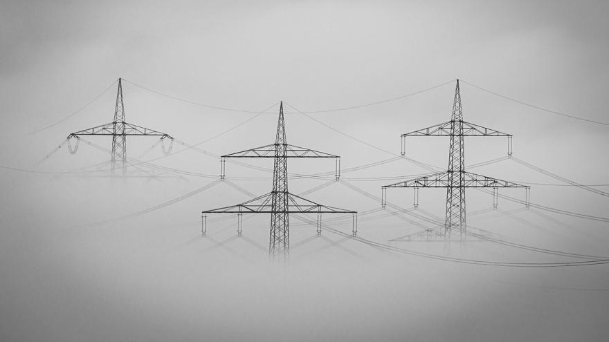 Drei Strommasten im Nebel
