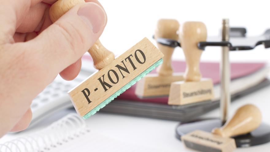 Hand hält Stempel mit der Aufschrift P-Konto