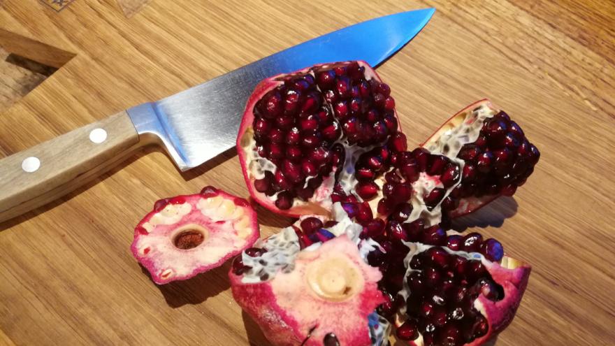 Granatapfel aufgebrochen auf einem Holzbrett