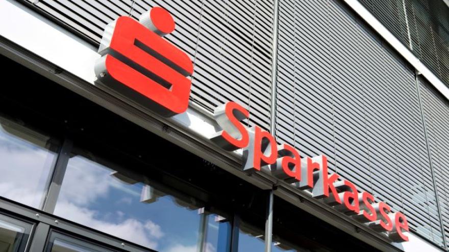 Der rote Schriftzug Sparkasse und das Sparkassensymbol an einer Hauswand