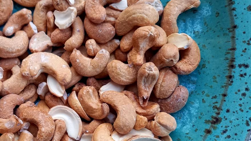 Cashewkerne liegen auf einem blauen Teller.